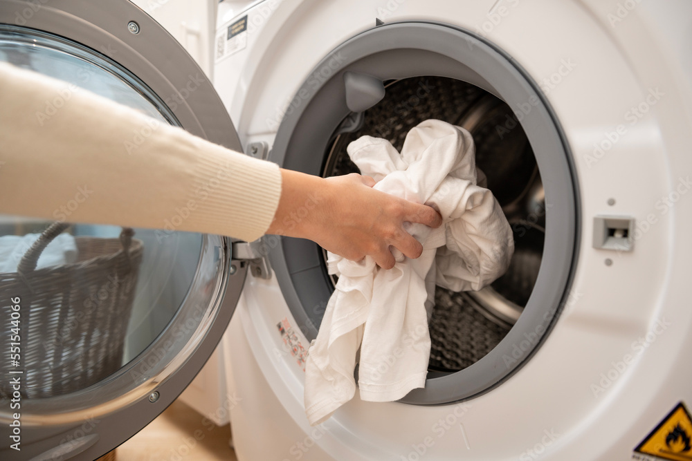 Close-up woman hand is keeping clothes in washing machine , health care lifestyle concept Close-up woman hand is keeping clothes in washing machine , health care lifestyle concept