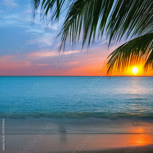 Beautiful palm branch on a tropical island beach on a background of yellow and blue sky with slight clouds and blue ocean. Calm Sunset