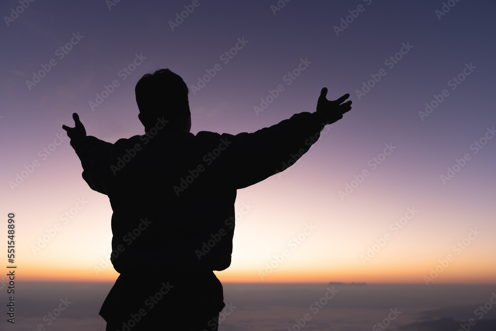 Silhouette of a human hand opens its palm to worship. the sun is rising concept of christianity Fight and win for God. Human freedom. Christian faith and success.