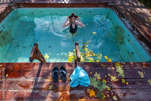 Photography Female wearing  swimsuit and  hat bathing in hot spring pool on sunny day