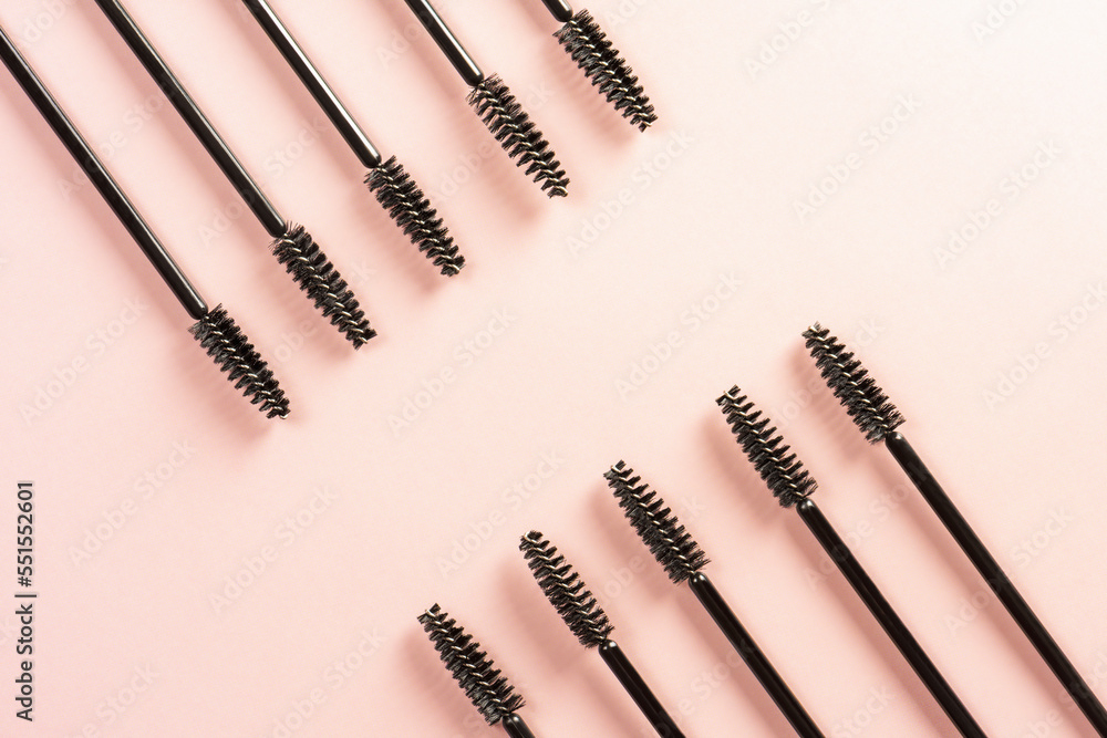 Black brushes and applicators for eyelashes and eyebrows on pink background. Womens cosmetics. Makeup for the face. Black brushes and applicators for eyelashes and eyebrows on pink background. Womens cosmetics. Makeup for the face.