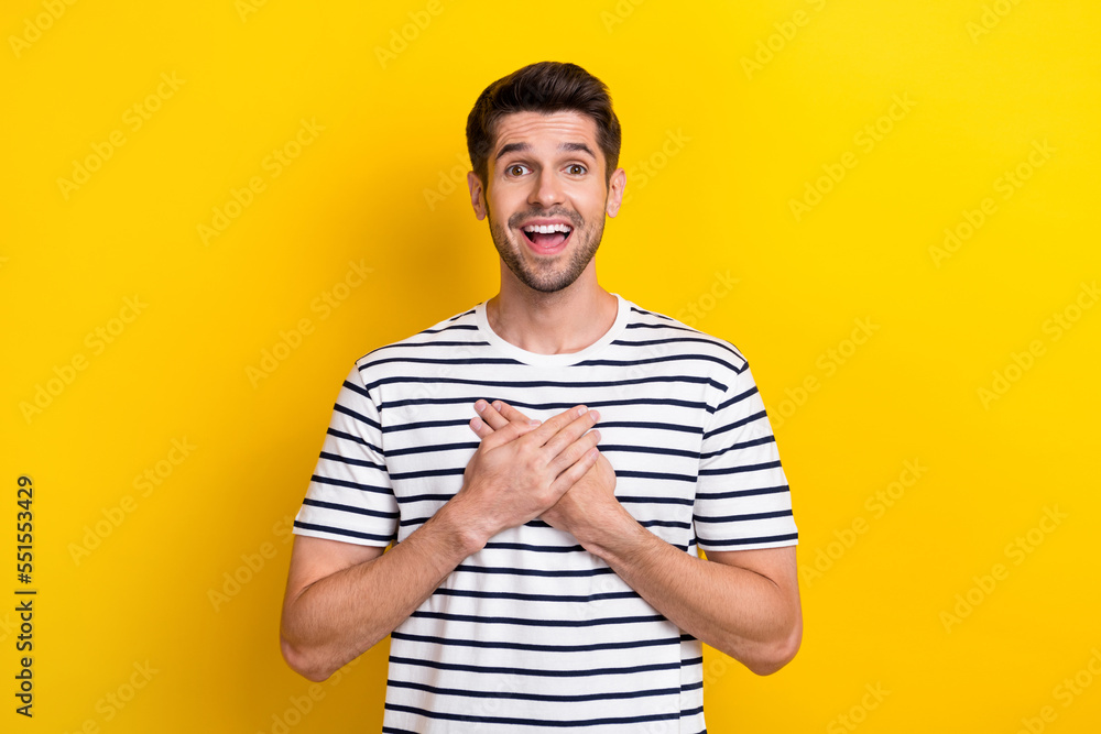 Photo of impressed cheerful young man open mouth arms touch chest unbelievable isolated on yellow color background Photo of impressed cheerful young man open mouth arms touch chest unbelievable isolated on yellow color background