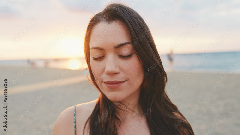 Portrait of young woman standing on the beach at sunrise Portrait of young woman standing on the beach at sunrise