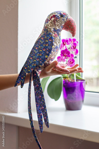 Soft textile toy - parrot bird. Interior toy sits on the hand. Beautiful handmade craft. photo