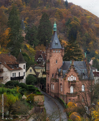 Fototapeta Naklejka Na Ścianę i Meble -  Stately brick castle on hillside of autumn colored trees with winding road.