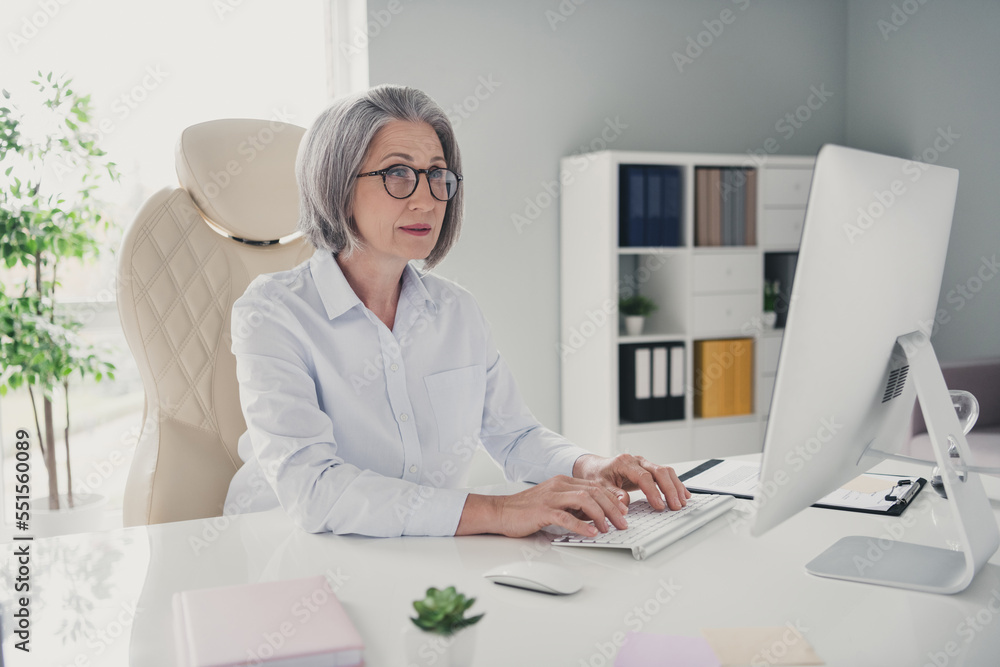 Photo portrait of mature old lady start up executive manager director working sitting bright modern work station typing computer - obrazy, fototapety, plakaty 