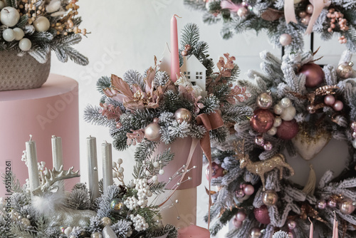 Christmas festive background with a floral arrangement of Christmas tree branches and candles for a gift. New Year's decor for the interior. Place for text.