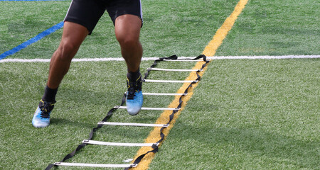 Legs of an athlete running side to side in a football ladder drill