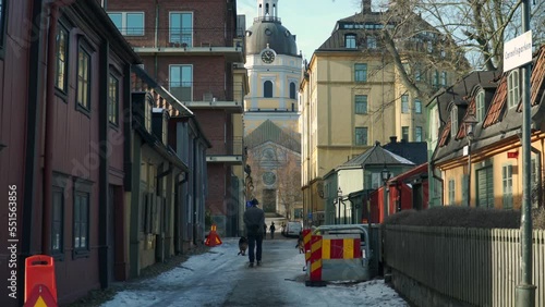 man with two dogs walking to a church in stocholm