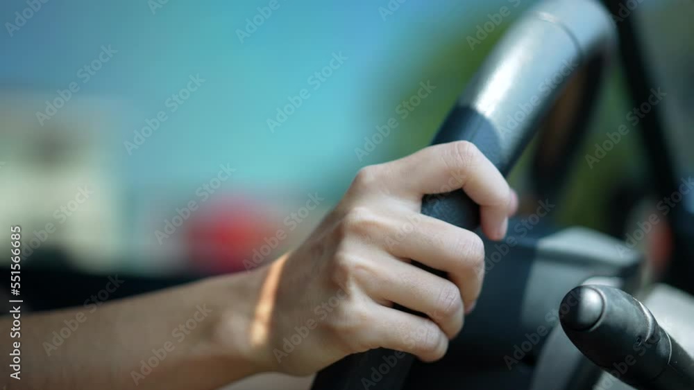 Closeup of person hands on steering wheel driving car. Woman driving a vehicle. Slow-motion driving commuting from work Closeup of person hands on steering wheel driving car. Woman driving a vehicle. Slow-motion driving commuting from work