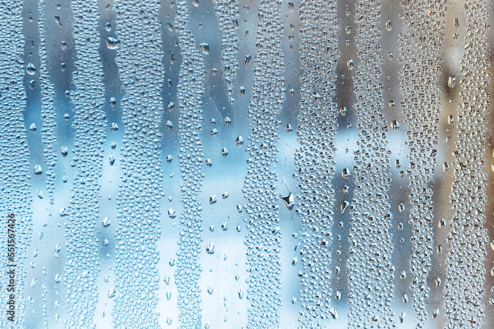 Background of natural drops of condensate on the surface of the glass, humidity on the window from the temperature difference outside. The texture of raindrops flowing down, a natural phenomenon. Background of natural drops of condensate on the surface of the glass, humidity on the window from the temperature difference outside. The texture of raindrops flowing down, a natural phenomenon.