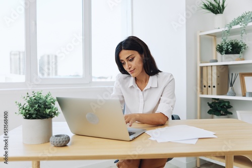Woman business works at her laptop at home in her office, freelance employee in business