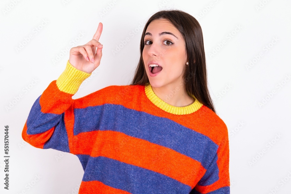 MODEL pointing finger up and looking inspired by genius thought, showing good idea sign, having clever solution in mind MODEL pointing finger up and looking inspired by genius thought, showing good idea sign, having clever solution in mind
