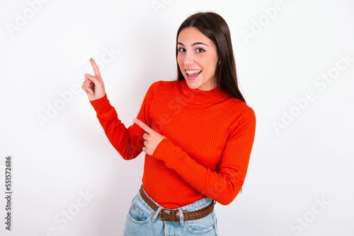 Young caucasian woman wearing red sweater over white background points at copy space indicates for advertising gives right direction