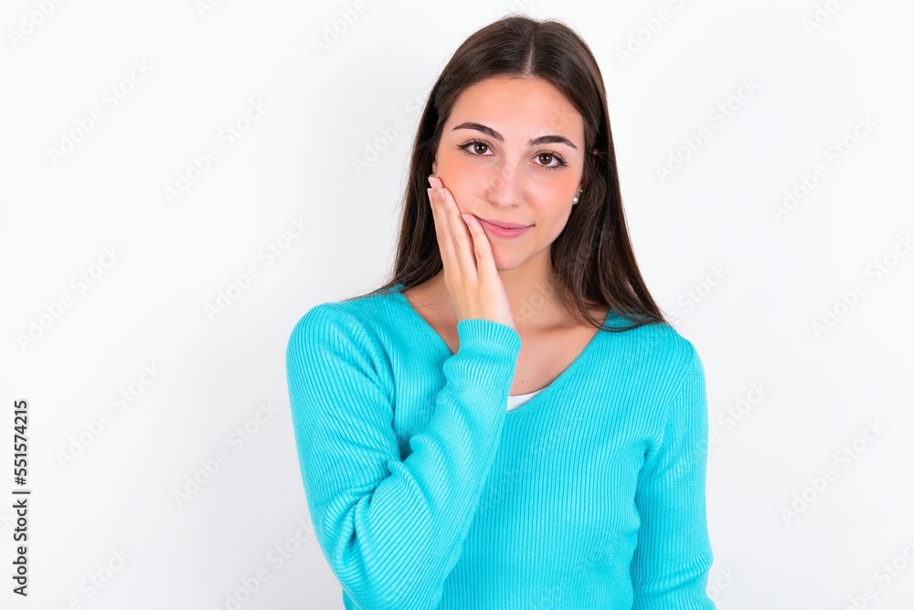 Photo of Young caucasian woman wearing blue sweater over white background enjoy fresh perfect smooth skin touch face Photo of Young caucasian woman wearing blue sweater over white background enjoy fresh perfect smooth skin touch face