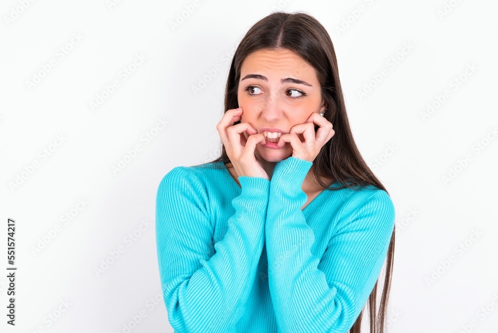 Terrified Young caucasian woman wearing blue sweater over white background looks empty space home alone moonless night Terrified Young caucasian woman wearing blue sweater over white background looks empty space home alone moonless night