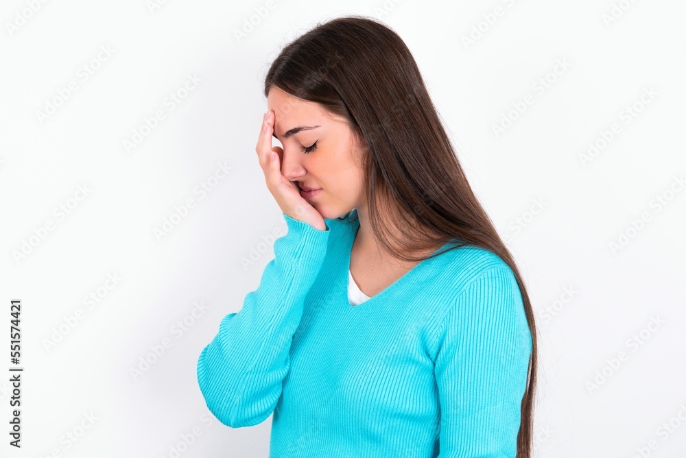 Young caucasian woman wearing blue sweater over white background with sad expression covering face with hands while crying. Depression concept. Young caucasian woman wearing blue sweater over white background with sad expression covering face with hands while crying. Depression concept.