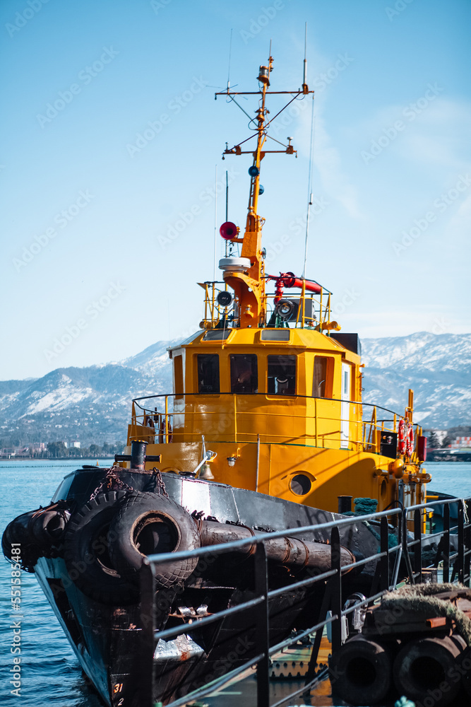 bright yellow boat in the seaport against the backdrop of mountains bright yellow boat in the seaport against the backdrop of mountains