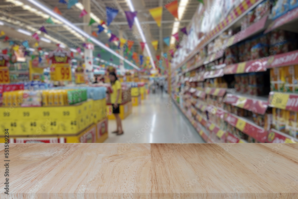 Wooden table top (counter bar) with blur supermarket grocery store background. Banner for advertise on online media. For montage product display visual layout. Business and shopping concepts. Wooden table top (counter bar) with blur supermarket grocery store background. Banner for advertise on online media. For montage product display visual layout. Business and shopping concepts.