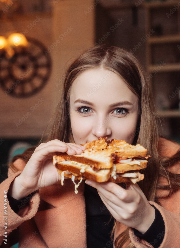 beautiful young woman in a cafe eating a sandwich beautiful young woman in a cafe eating a sandwich