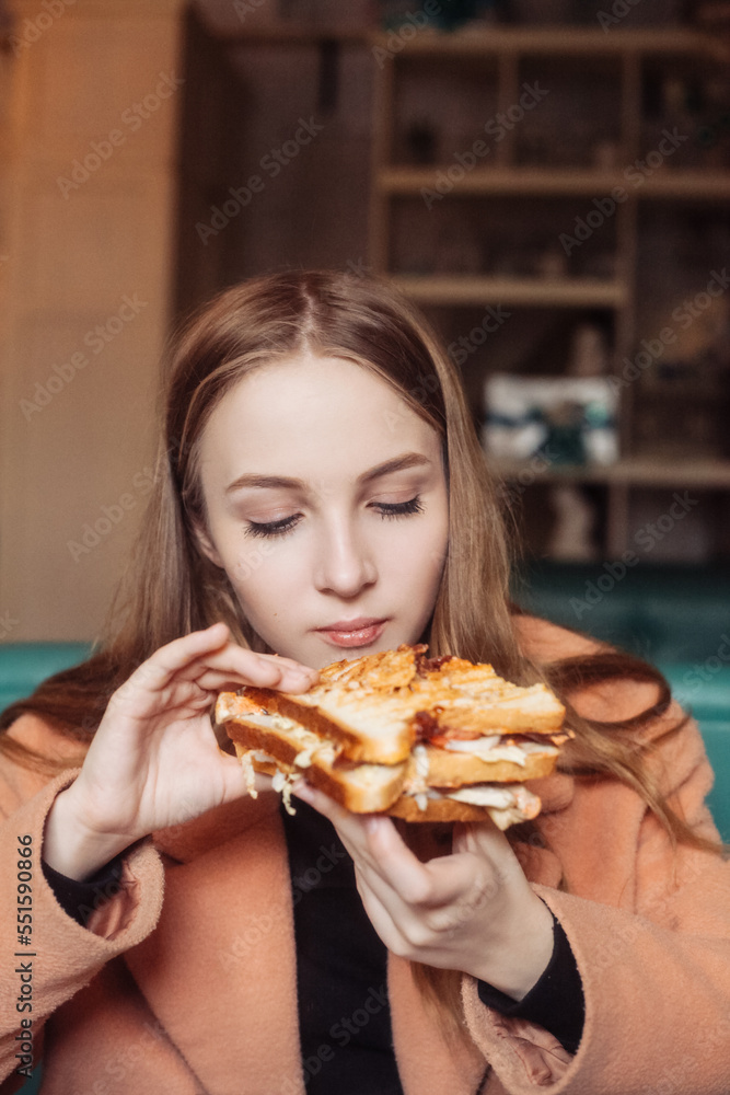 beautiful young woman in a cafe eating a sandwich beautiful young woman in a cafe eating a sandwich