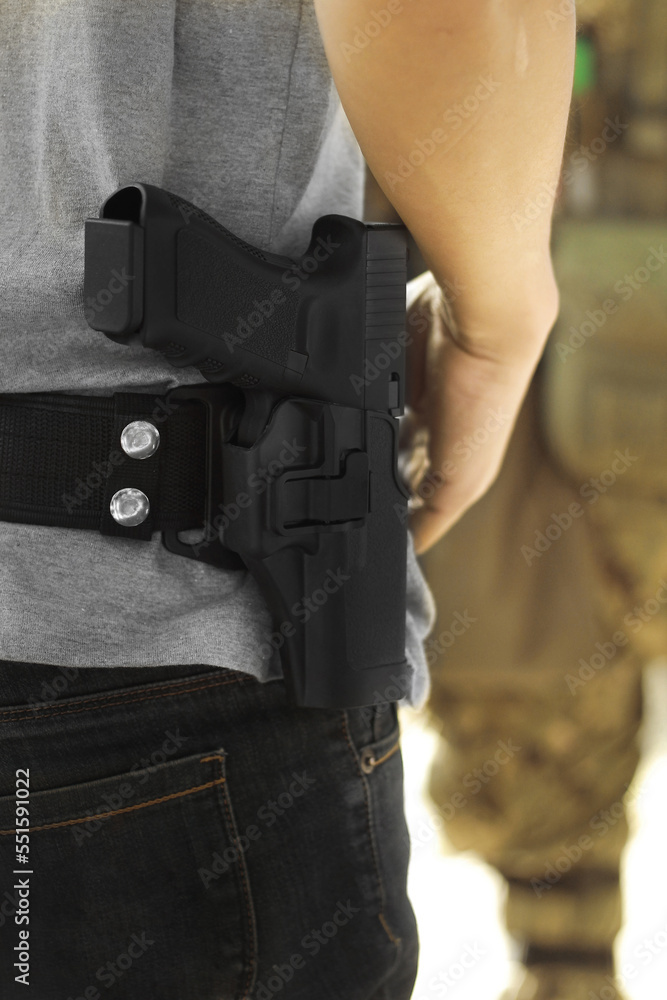 Man carrying pistol weapon in holster at hip belt. Man carrying pistol weapon in holster at hip belt.