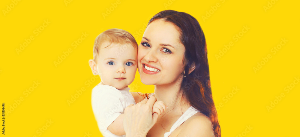 Portrait of happy smiling mother holding her baby isolated on yellow background Portrait of happy smiling mother holding her baby isolated on yellow background