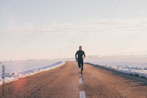 Man running on a road in winter