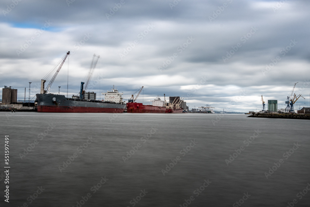 Grey and red cargo ships on the docks. Titanic Quarter, Belfast, Northern Ireland