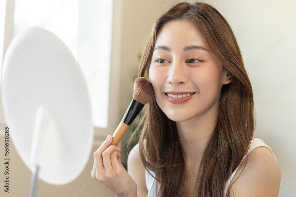 Happy routine beauty concept, pretty asian young woman, girl make up face by applying powder foundation by brush around face, looking at the mirror at home. Female look with natural fashion style. Happy routine beauty concept, pretty asian young woman, girl make up face by applying powder foundation by brush around face, looking at the mirror at home. Female look with natural fashion style.