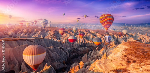 Aerial view amazing sunrise landscape in Cappadocia with colorful hot air balloon fly in sky over deep canyons, valleys. Concept banner travel Turkey © Parilov