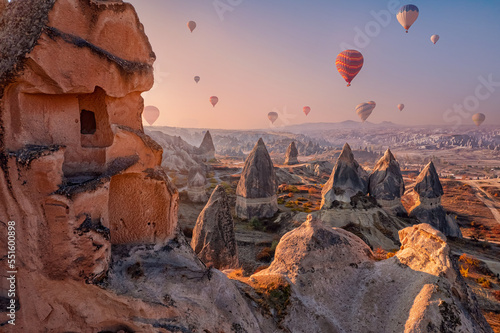 Closeup ancient Goreme cave in big stone, hot air balloons fly over deep canyons, valleys Cappadocia National Park, Banner Turkey Travel © Parilov
