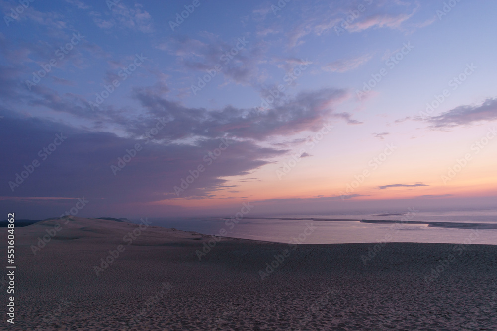 Twilight after sunset with view at the sea on a huge natural sand formation on the Dune du Pilat, Arcachon, Nouvelle-Aquitaine, France Twilight after sunset with view at the sea on a huge natural sand formation on the Dune du Pilat, Arcachon, Nouvelle-Aquitaine, France