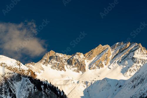Alpine mountain peaks glow in the winter evening sun