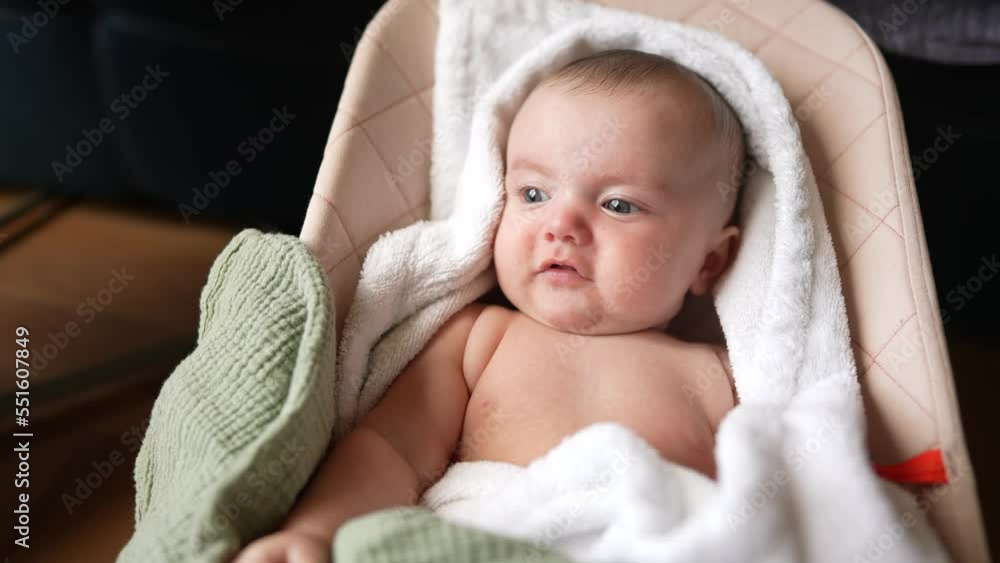 newborn baby swinging in a rocking chair. happy family kid dream concept. baby lifestyle newborn close-up looking at the camera. child infant wrapped in a towel swinging on a sun lounger rocking chair newborn baby swinging in a rocking chair. happy family kid dream concept. baby lifestyle newborn close-up looking at the camera. child infant wrapped in a towel swinging on a sun lounger rocking chair