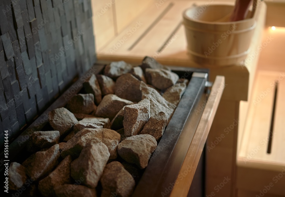 Sauna bucket with water beside the stone in finnish sauna room.
