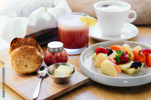 Traditional American breakfast, juice, coffee, fruit and bread on a table.