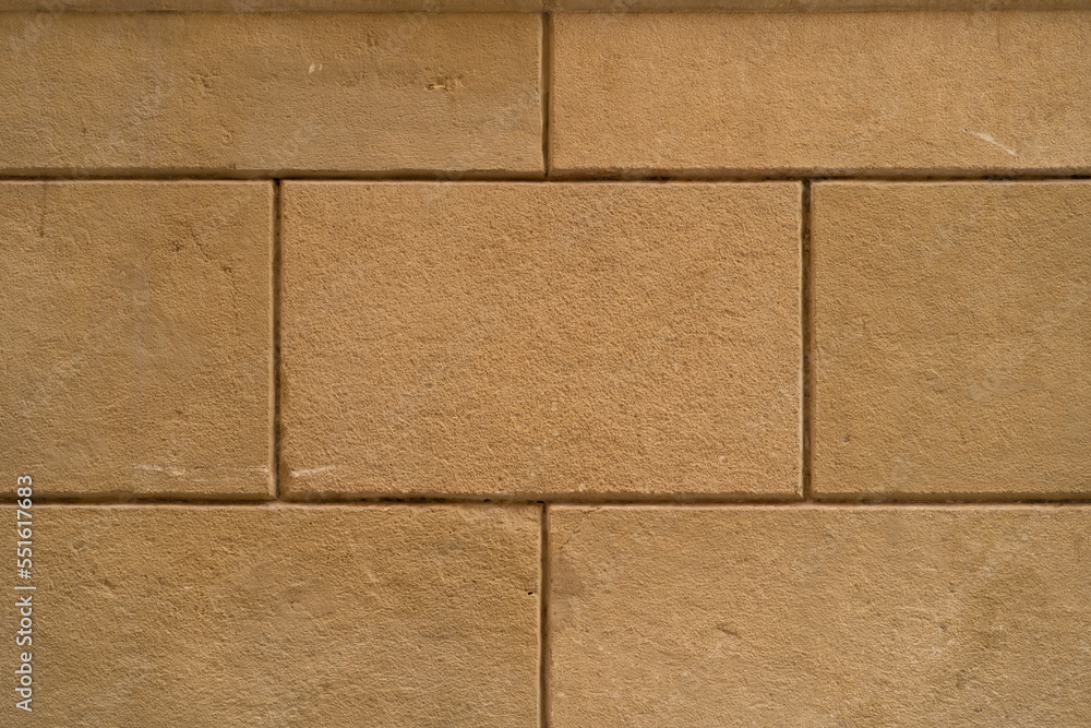 Naklejka premium Background texture of restored old wall, pattern and symmetry, orange rectangular blocks. landscape photo