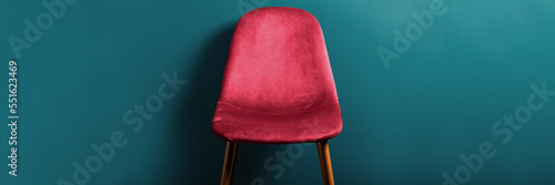 Modern Velour Chair Viva Magenta, color of the year 2023 on wooden legs, blue background, banner size