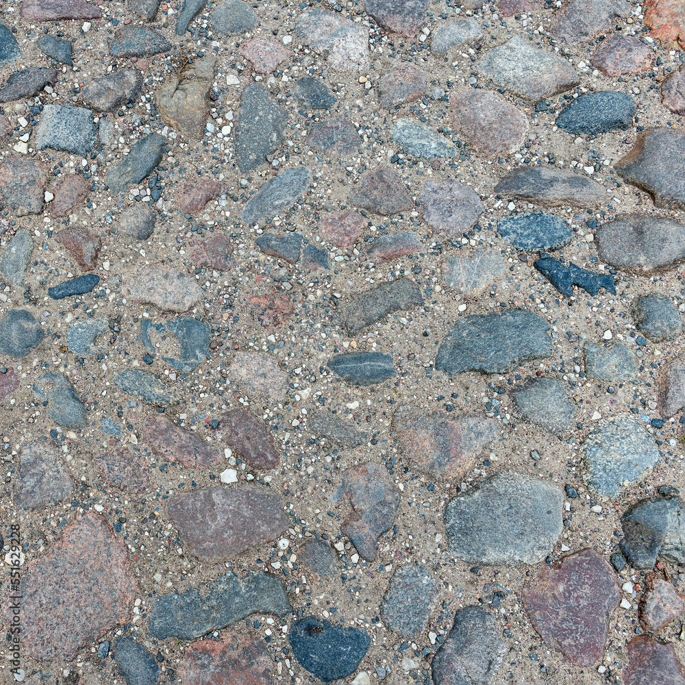 Old stone road of stones of different sizes and colors as a natural background Old stone road of stones of different sizes and colors as a natural background