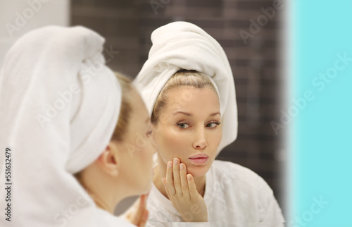 Woman looking in the mirror Applying the cream..Magic anti-aging cream