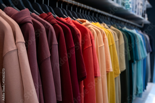 Colorful hoodies on hangers in store