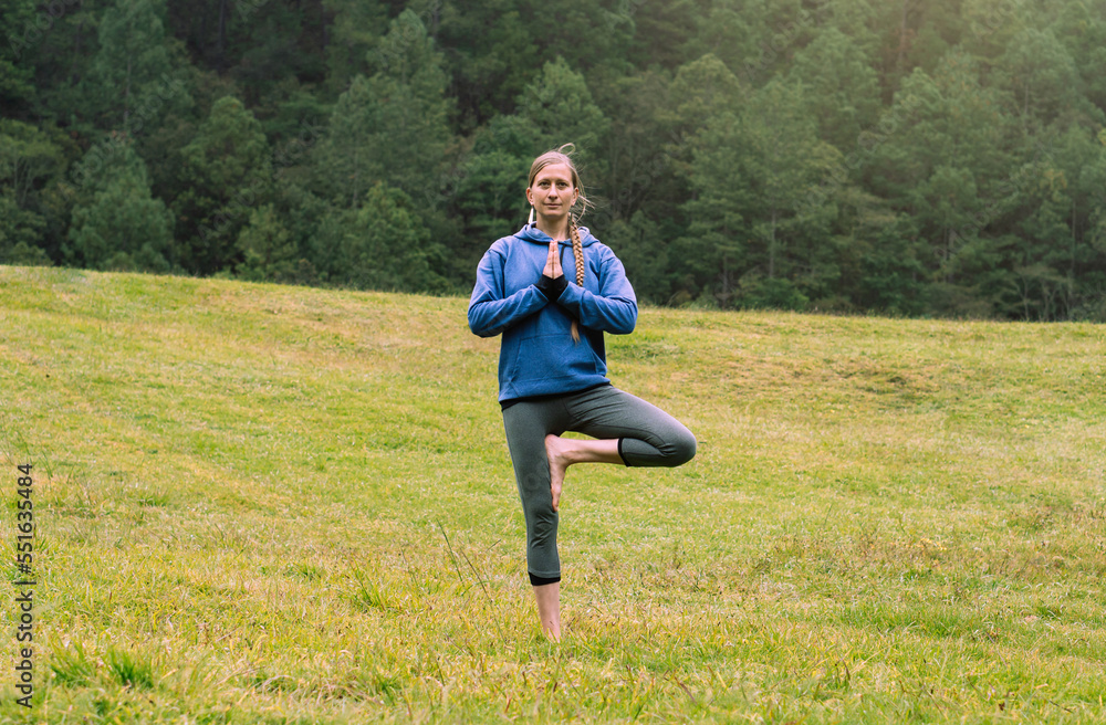 Obraz premium Mature woman in a forest practicing yoga, copy space. Mental health.