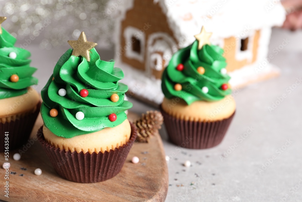 Christmas tree shaped cupcakes on light grey table Christmas tree shaped cupcakes on light grey table