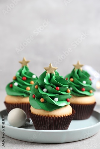Christmas tree shaped cupcakes on light grey table