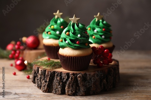 Quadro su tela Christmas tree shaped cupcakes on wooden stand, closeup