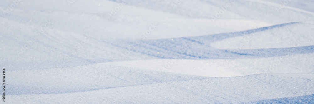 Beautiful winter background with snowy ground. Natural snow texture. Wind sculpted patterns on snow surface. Arctic, Polar region.