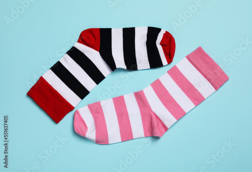 Different stiped socks on light blue background, flat lay