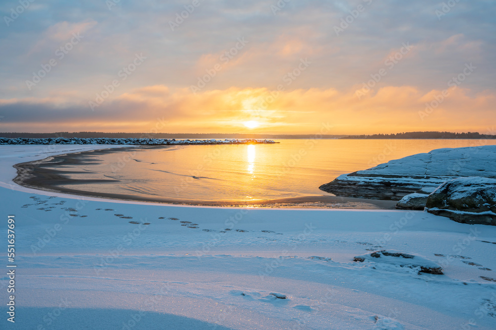 Winter sunset over a snowy beach and sea. 
Vexala, Finland.