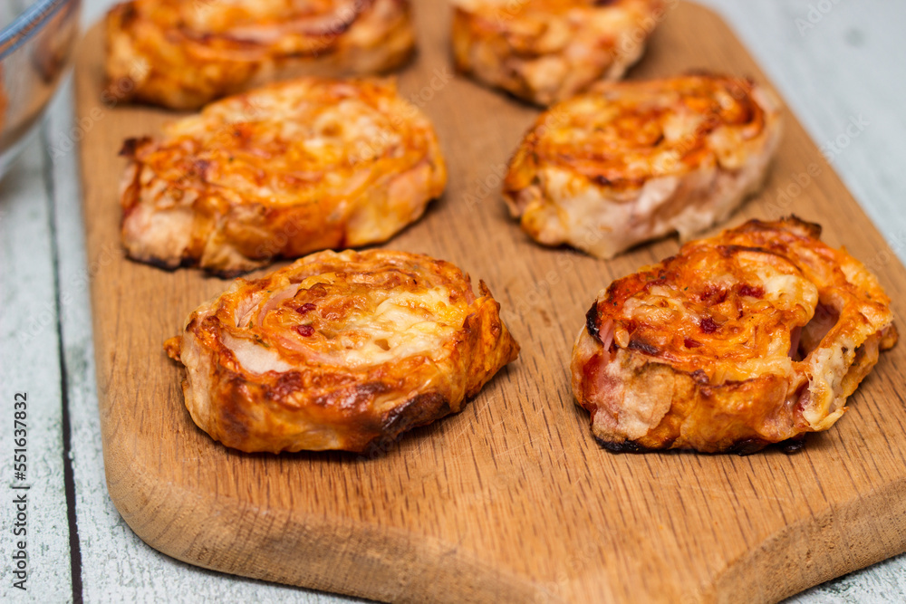 Homemade mini pizza buns topped with tomato sauce, ham and cheese